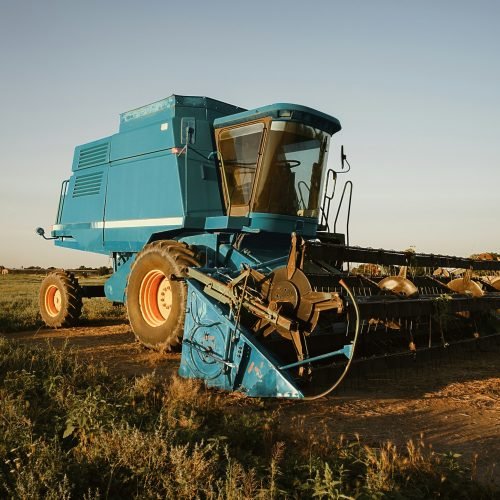 Blue combine harvester agriculture machine harvesting in a field